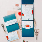 bright blue envelopes with pops of red and a wax seal flatlay