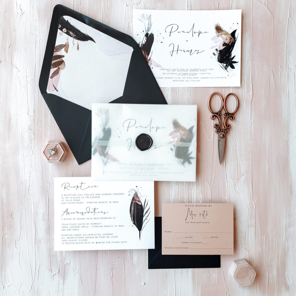 black envelopes with feather design and vintage scissors
