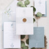 blue and white invitations with gold seal