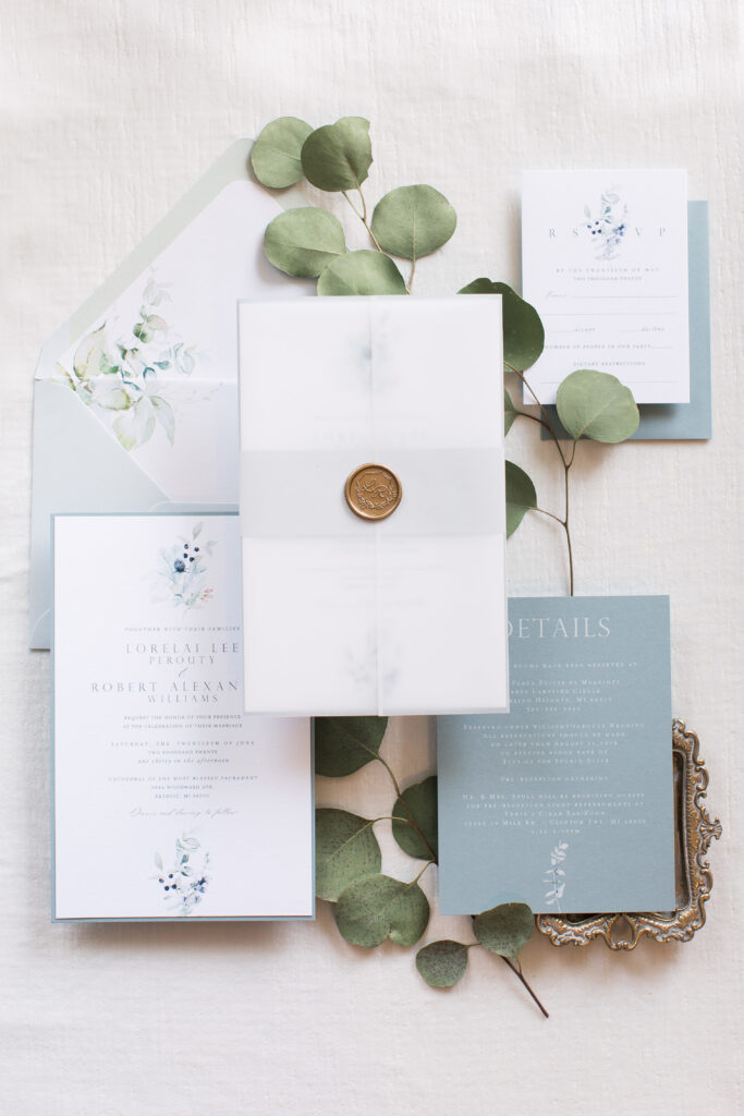 blue and white invitations with gold seal