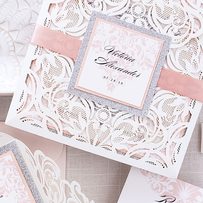 laser-cut invitation with pink bellyband