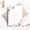 light pink envelope with white save the date card and pink flowers