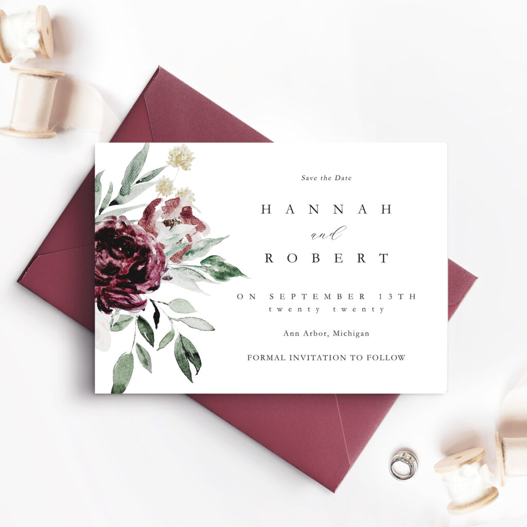 red purple envelope with white save the date card and flowers
