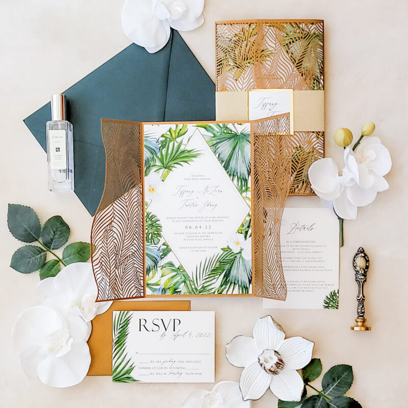 Palm leaf laser cut wedding invitations featuring intricate tropical designs, perfect for luxurious beach or destination weddings.