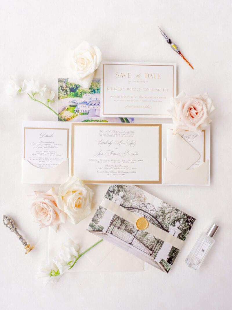 Elegant gold and ivory wedding folio with vellum band and wax seal.