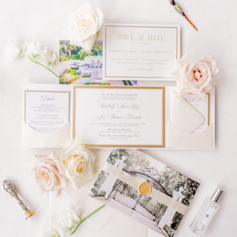 Elegant gold and ivory wedding folio with vellum band and wax seal.