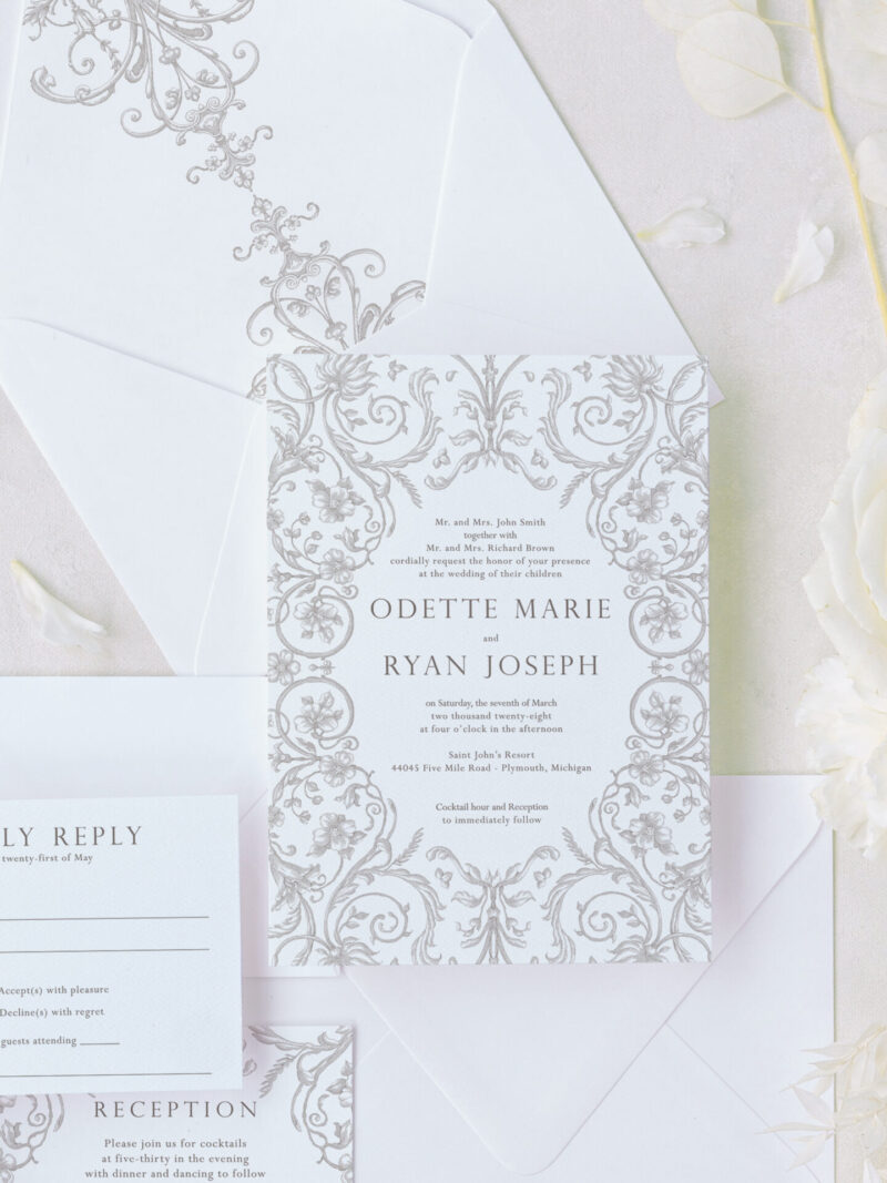 Ornate wedding invitation suite with regency-inspired scrollwork, textured cardstock, and matching envelope liner featuring elegant designs.