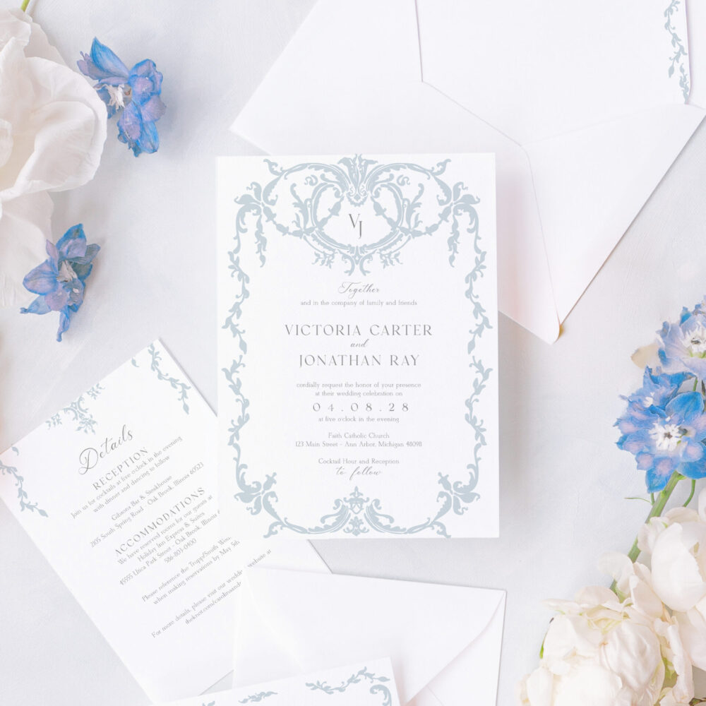 Elegant regency wedding invitation suite with blue and white design, featuring textured cardstock, scrollwork details, and matching envelope liners.