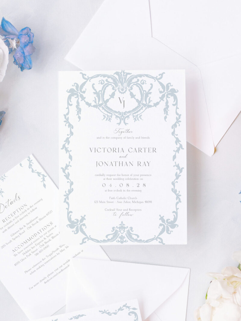 Elegant regency wedding invitation suite with blue and white design, featuring textured cardstock, scrollwork details, and matching envelope liners.