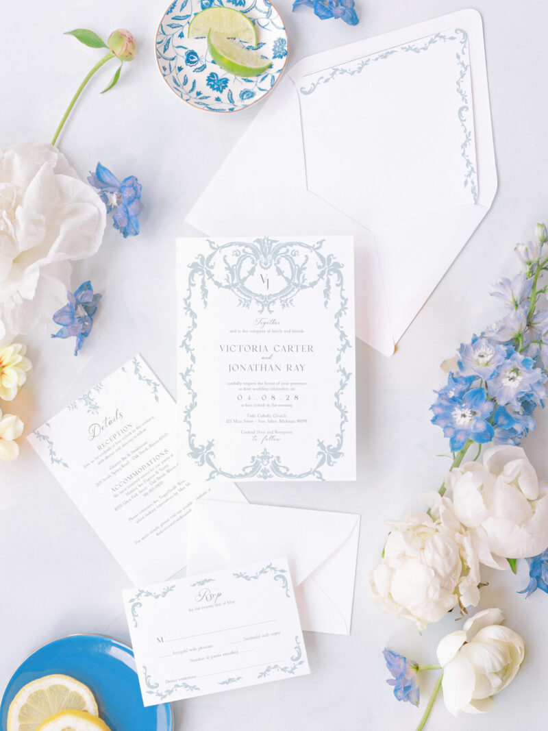 Regency-inspired wedding invitation suite in blue and white with intricate scrollwork, matching RSVP card, details card, and envelope liner.