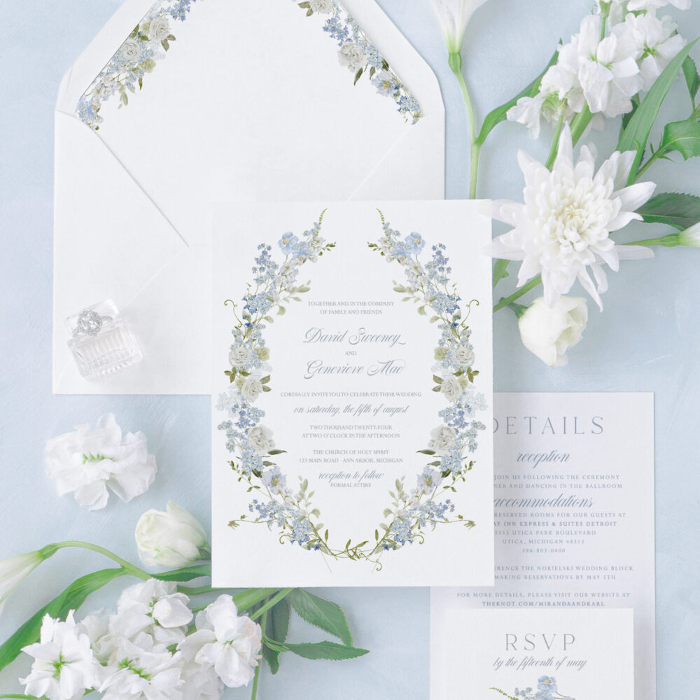 Blue floral wedding invitation suite with romantic wreath design, matching RSVP card, details card, and floral envelope liner.