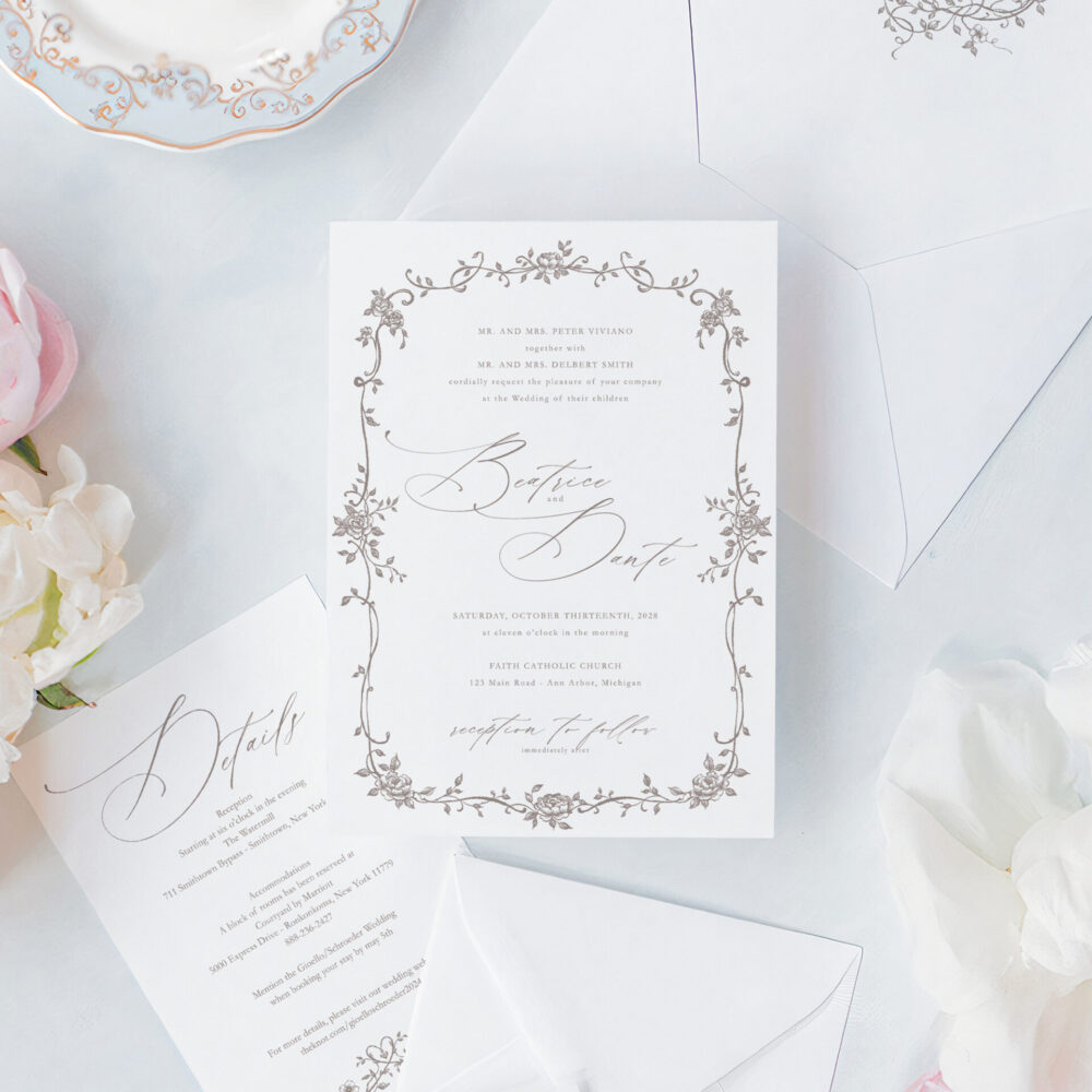 Romantic script wedding invitations with an elegant floral frame, matching RSVP card, details card, and floral envelope liner.