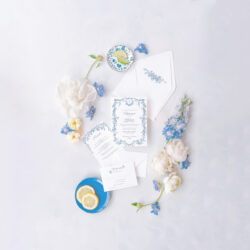 Blue floral wedding invitation suite with a Regency-inspired frame, surrounded by white and blue flowers, perfect for timeless weddings.