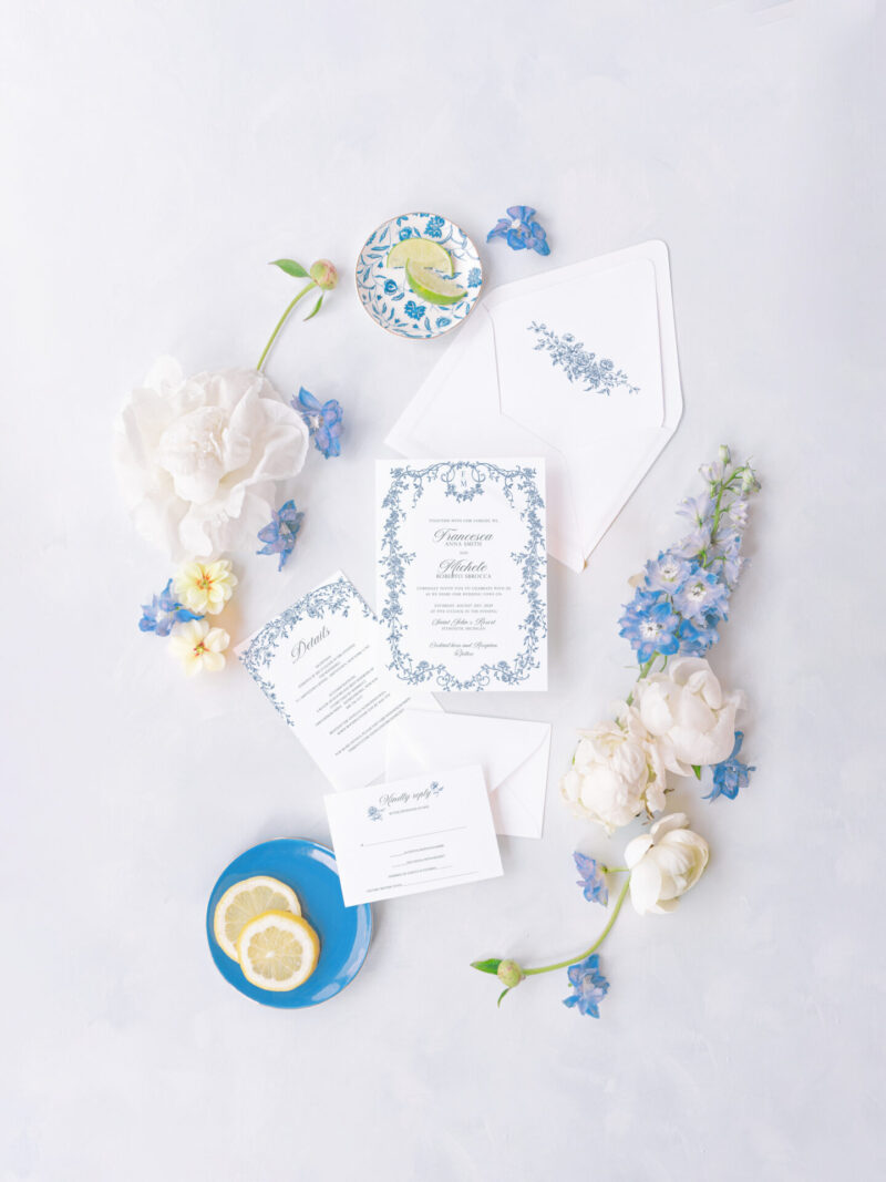 Blue floral wedding invitation suite with a Regency-inspired frame, surrounded by white and blue flowers, perfect for timeless weddings.