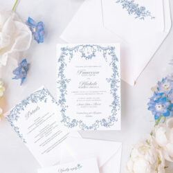 Elegant blue floral wedding invitation suite with Regency-inspired frame design, paired with delicate white and blue florals and styled details.