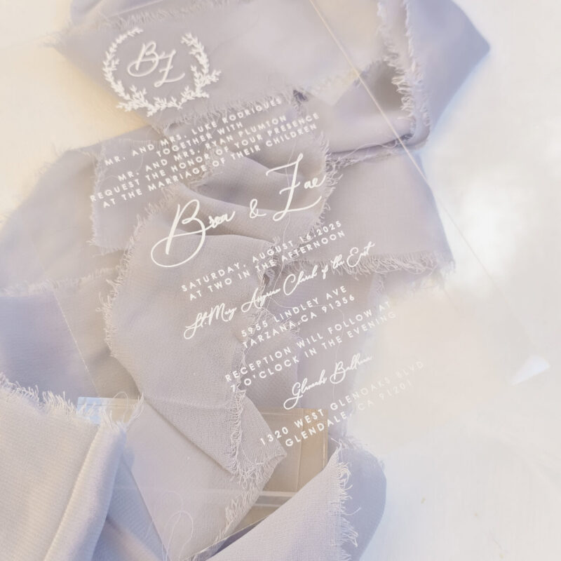 Clear acrylic wedding invitation with white ink and crest