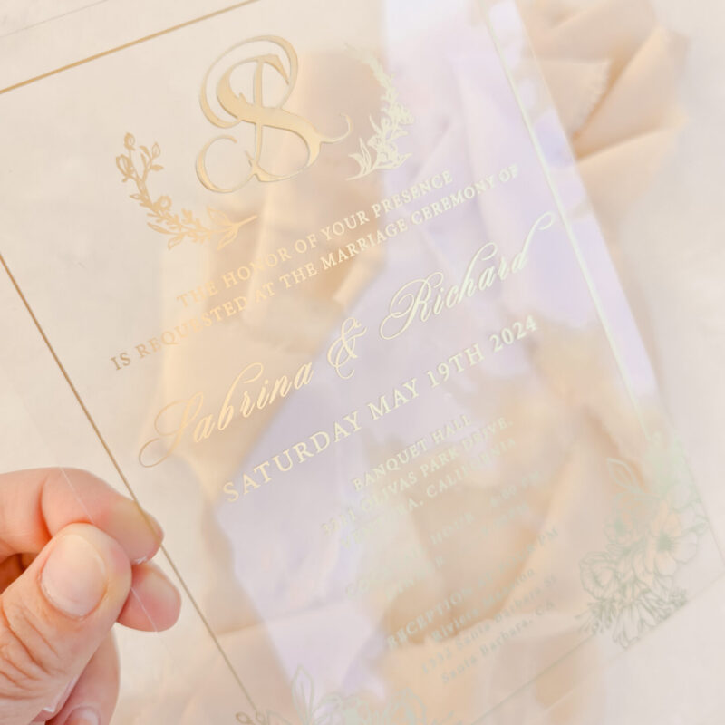 Plexiglass wedding invitation with gold raised monogram and gold print