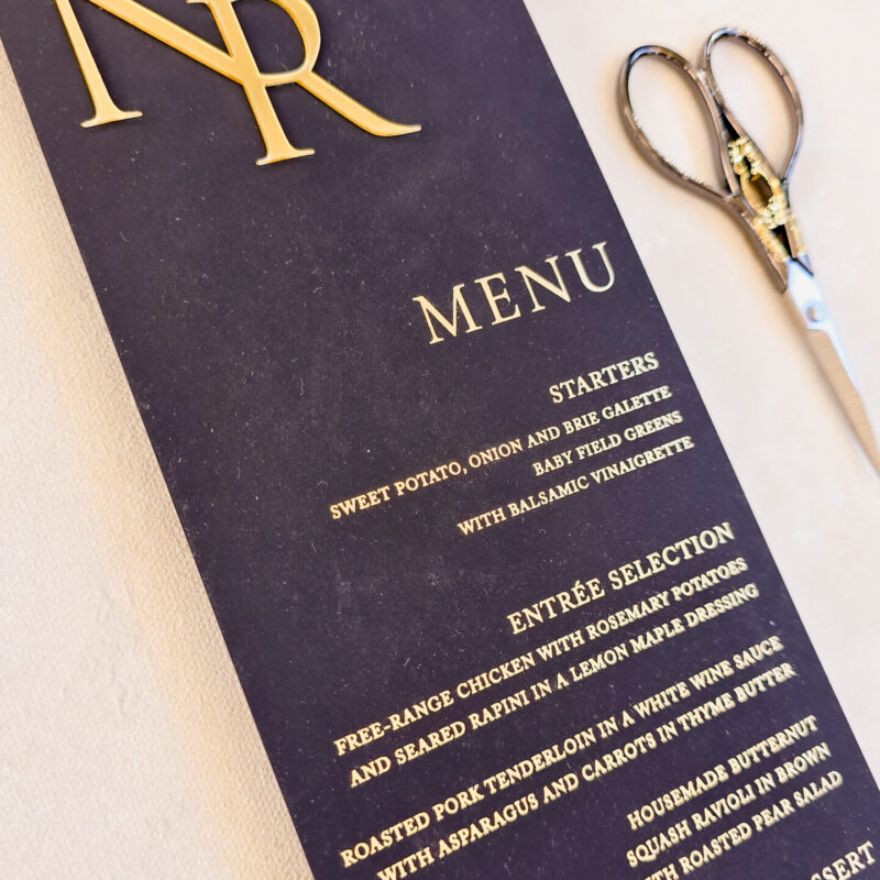 Simple black menu with gold acrylic monogram accent