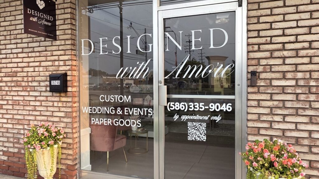Wedding invitation designer reviewing invitation suites and paper samples at Designed with Amore